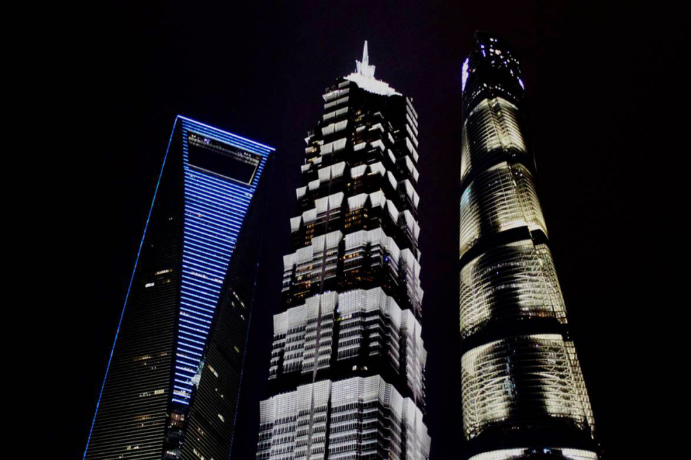 На фото Шанхайский всемирный финансовый центр — здание в виде открывашки, башня Цзинь Мао и Шанхайская башня. Расположены в центральном районе Шанхая Пудун