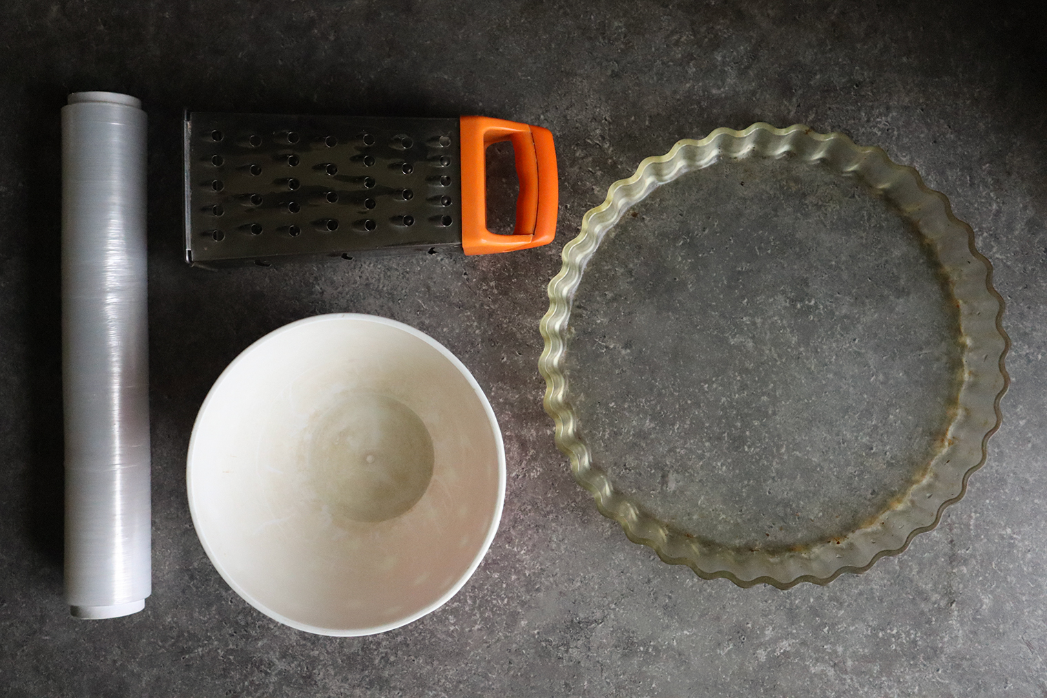 Из инвентаря понадобится миска для замешивания теста, форма для запекания, пищевая пленка и терка