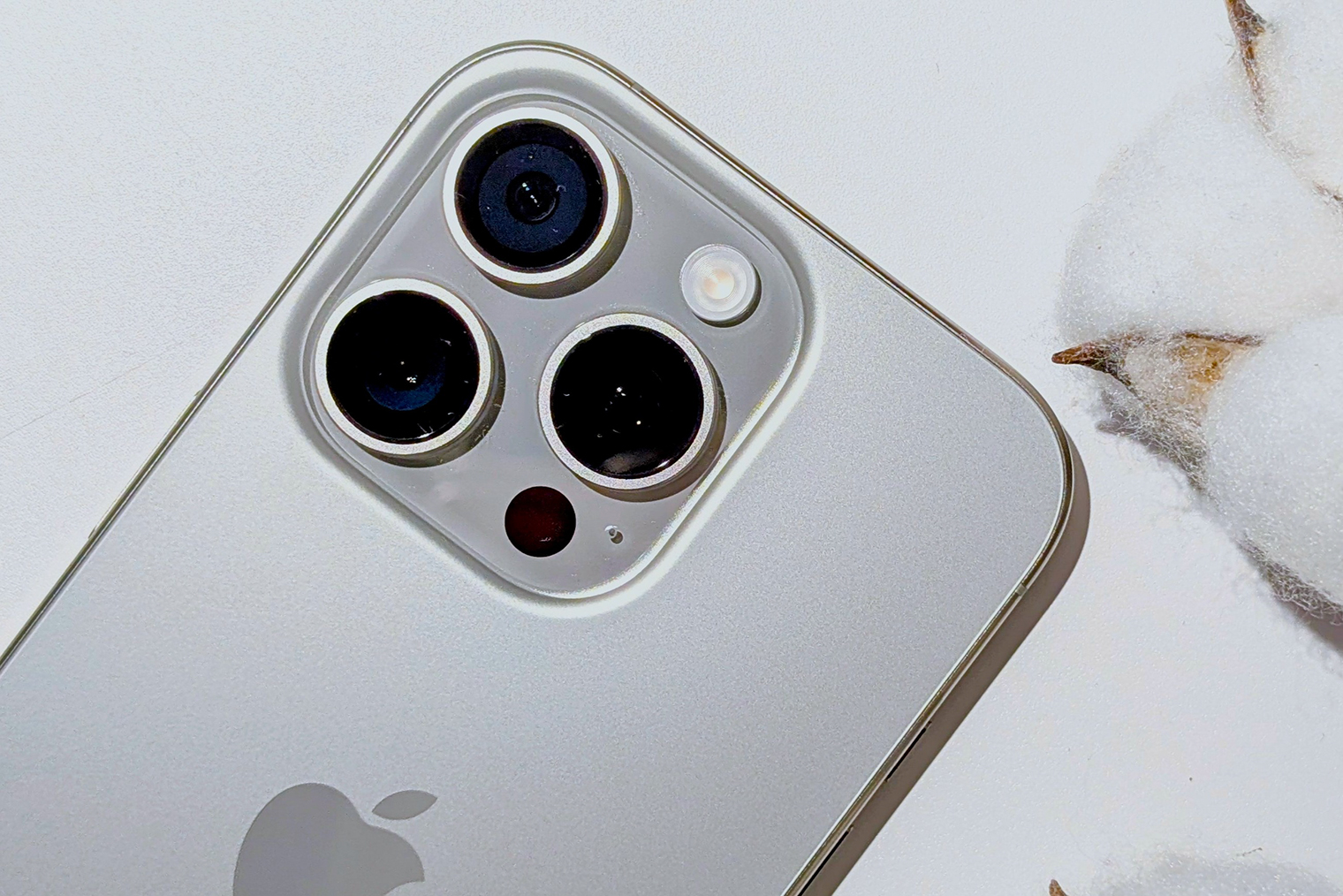 Это iPhone 16 Pro в цвете «серебристый титан» — задняя панель полностью стеклянная, а рамка корпуса сделана из титанового сплава