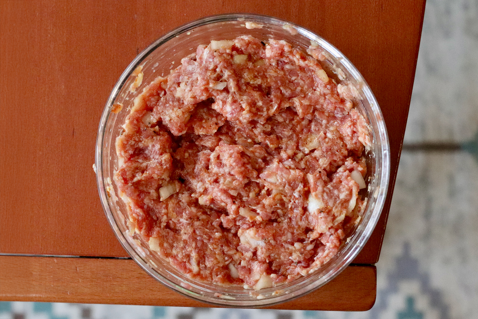 Шаг 1. Лук мелко нарежьте, смешайте с фаршем. Добавьте специи и воду