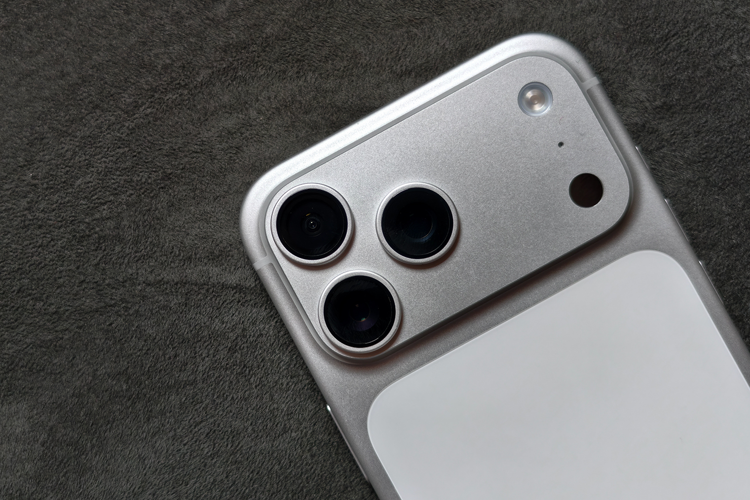 А это — iPhone 17 Pro Max в серебристом цвете — корпус целиком из алюминия, включая плато на всю ширину, а из стекла сделана только прямоугольная вставка сзади. Яблочко смещено вниз