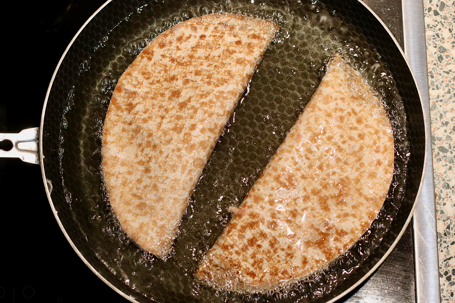 Шаг 4. Растительное масло разогрейте в сковороде. Проверяйте готовность зубочисткой или деревянной лопаткой, опуская их в жир: если пошли пузыри, значит, можно жарить. Чебуреки аккуратно выложите в масло, чтобы не разбрызгать