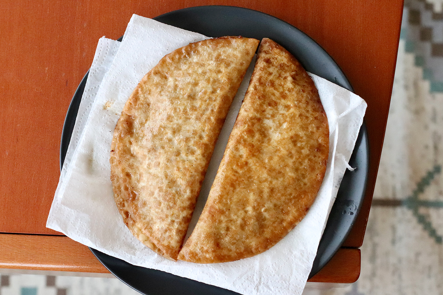 Шаг 6. Готовые чебуреки выложите на бумажные полотенца — они впитают лишнее масло. Дайте немного остыть и подавайте