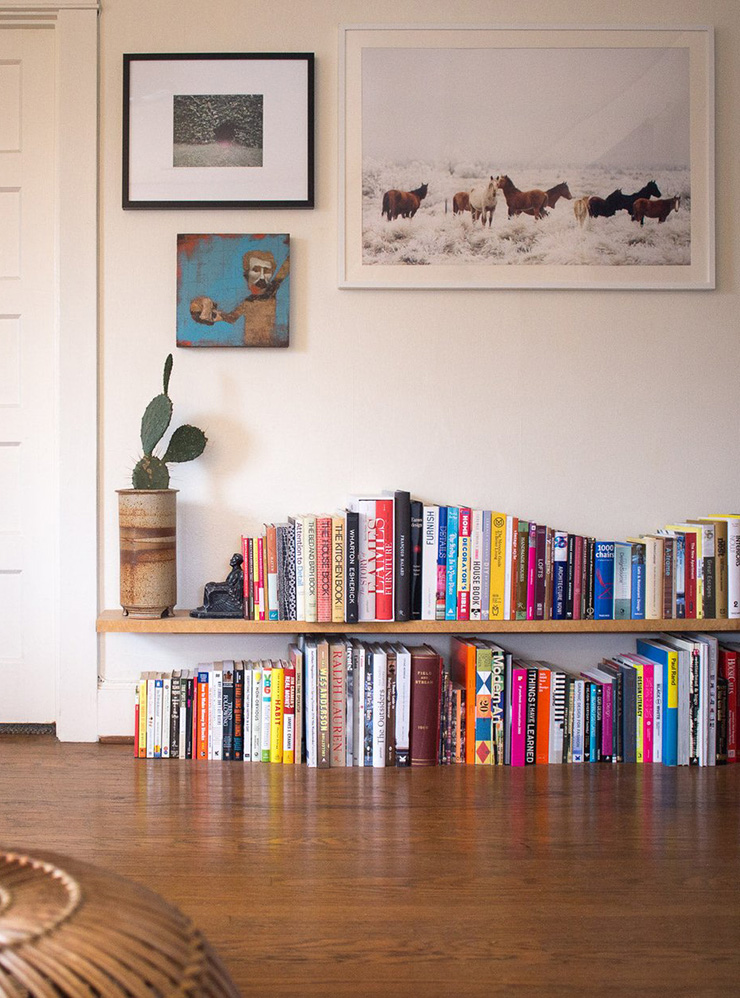Можно выставить книги на полу, как на полке. Так их удобнее брать. Чтобы такая инсталляция не разваливалась, прижмите ее с боков чем-нибудь тяжелым: горшками с цветами или увесистыми томами. Фото: Wood&Faulk / Pinterest