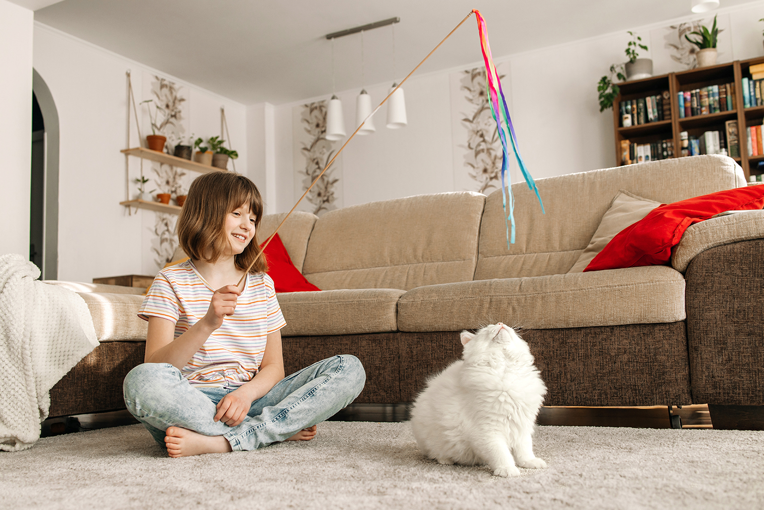 Игрушки-дразнилки помогают сохранять дистанцию между ребенком и кошкой во время игры. Фотография: Elena Medoks / Shutterstock / FOTODOM