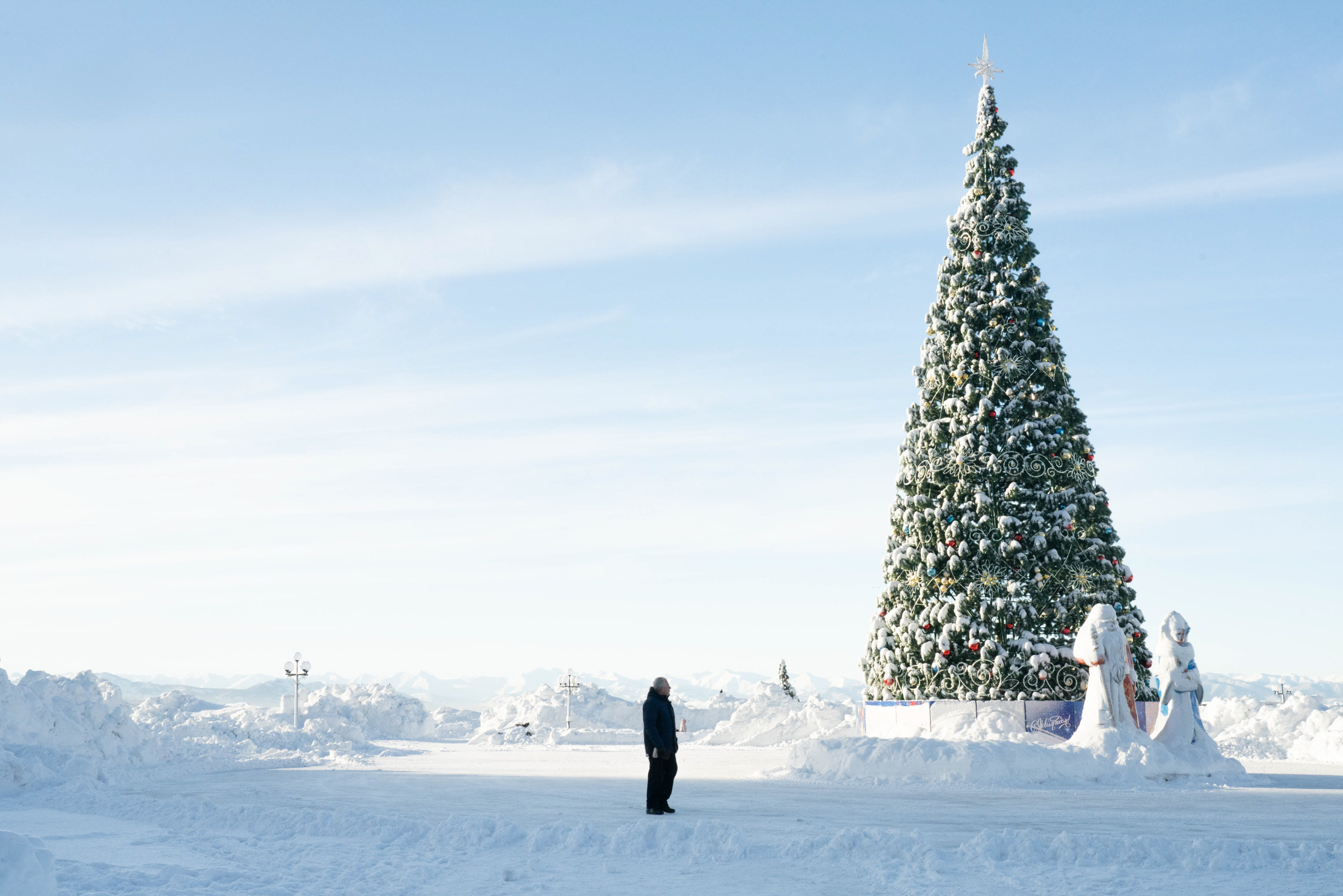 По данным Гидрометеоцентра Камчатки, снегопад на острове — рекордный за последние полвека. На снимке — житель у городской елки в центре Петропавловска-Камчатского