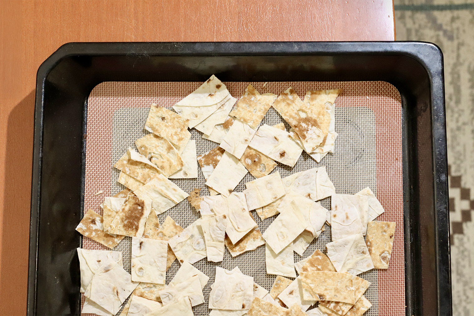 Шаг 1. Начните разогревать духовку до 180 °С. Лаваш нарежьте ножницами или ножом на прямоугольники размером 2 × 4 см. Противень застелите бумагой для выпечки или силиконовым ковриком, выложите кусочки лаваша