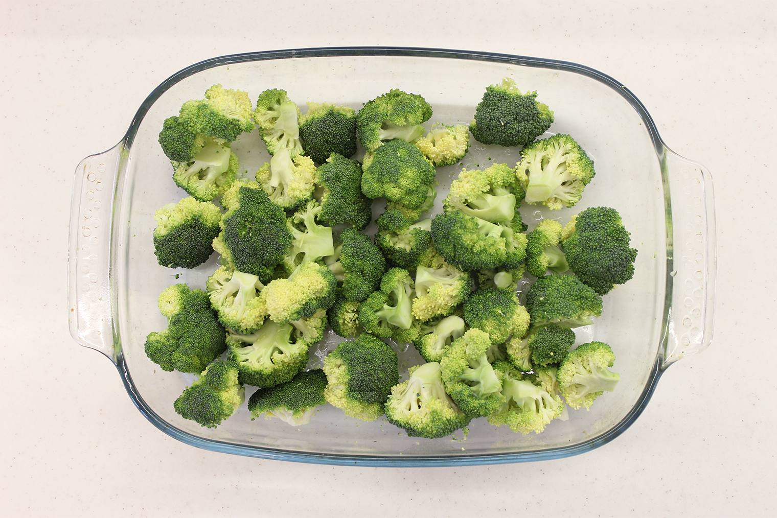 Шаг 1. Начните разогревать духовку до 180 °С. Брокколи промойте водой, соцветия отделите от кочерыжки. Удобно срезать капусту прямо в форму для запекания