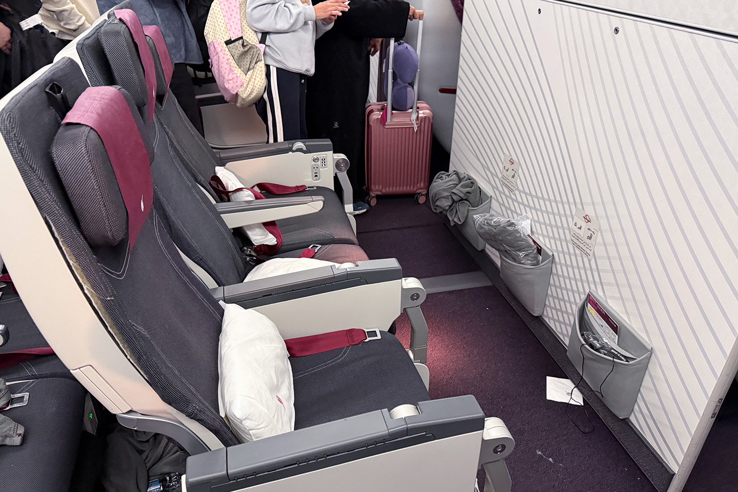 Места в начале салона самолета экономкласса на рейсе B787-9 Qatar Airways Москва — Доха. Они одни из самых дорогих, поскольку здесь есть дополнительное пространство для ног. Откидные столики спрятаны в ручках кресел. © Антонида Пашинина