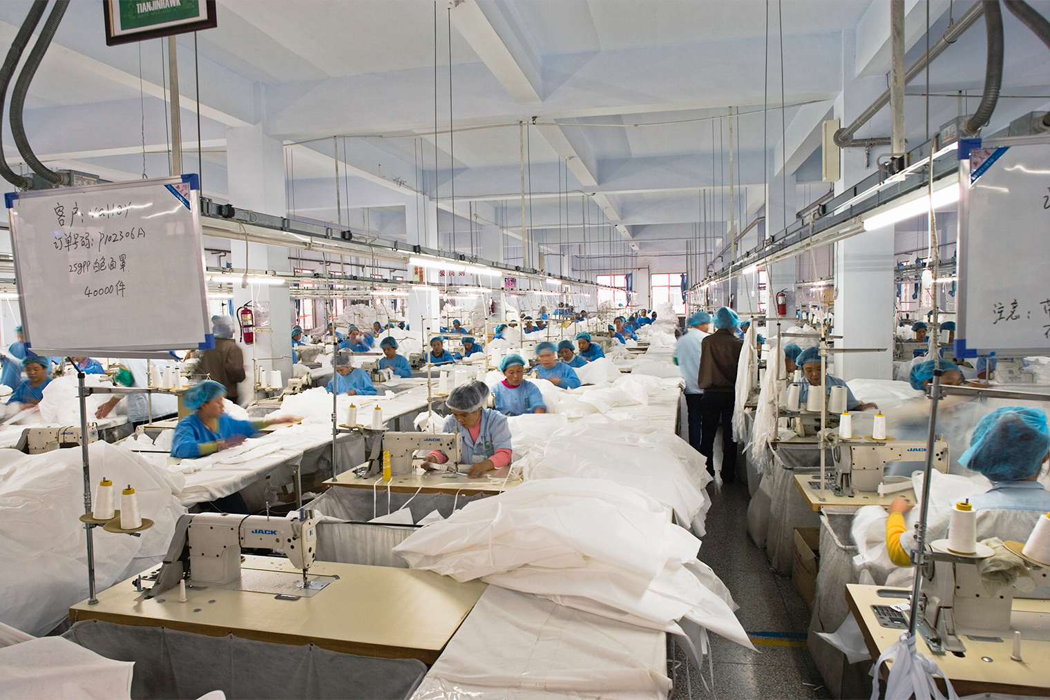 Китайские предприятия могут привлекать много работников и быстро расширяться под нужды заказчика. На текстильном производстве в городе Тяньцзинь шьют защитные костюмы. Фотография: Kim Steele / Getty Images