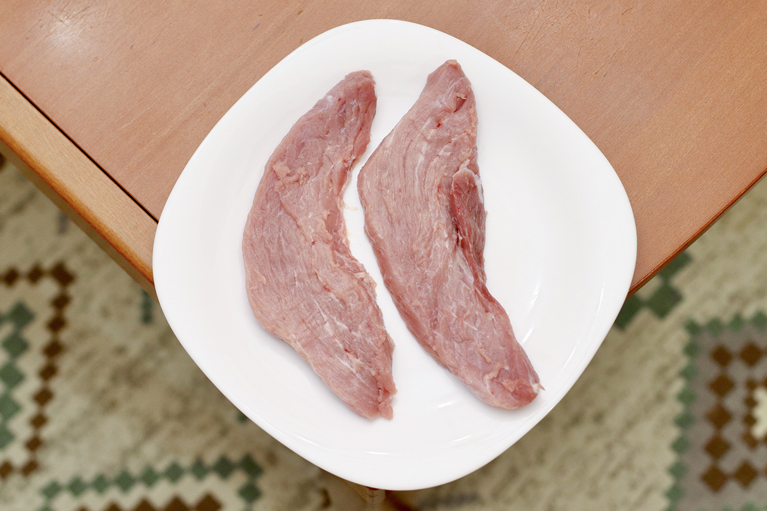 Шаг 1. Свинину нарежьте поперек волокон на куски толщиной около 2 см и весом около 150 г. Просушите бумажными полотенцами