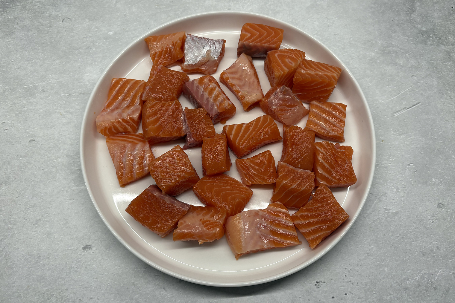 Шаг 1. Лосося отделите от кожи и нарежьте крупными кубиками. Выложите в кипящую подсоленную воду и варите 3—5 минут, пока филе не посветлеет