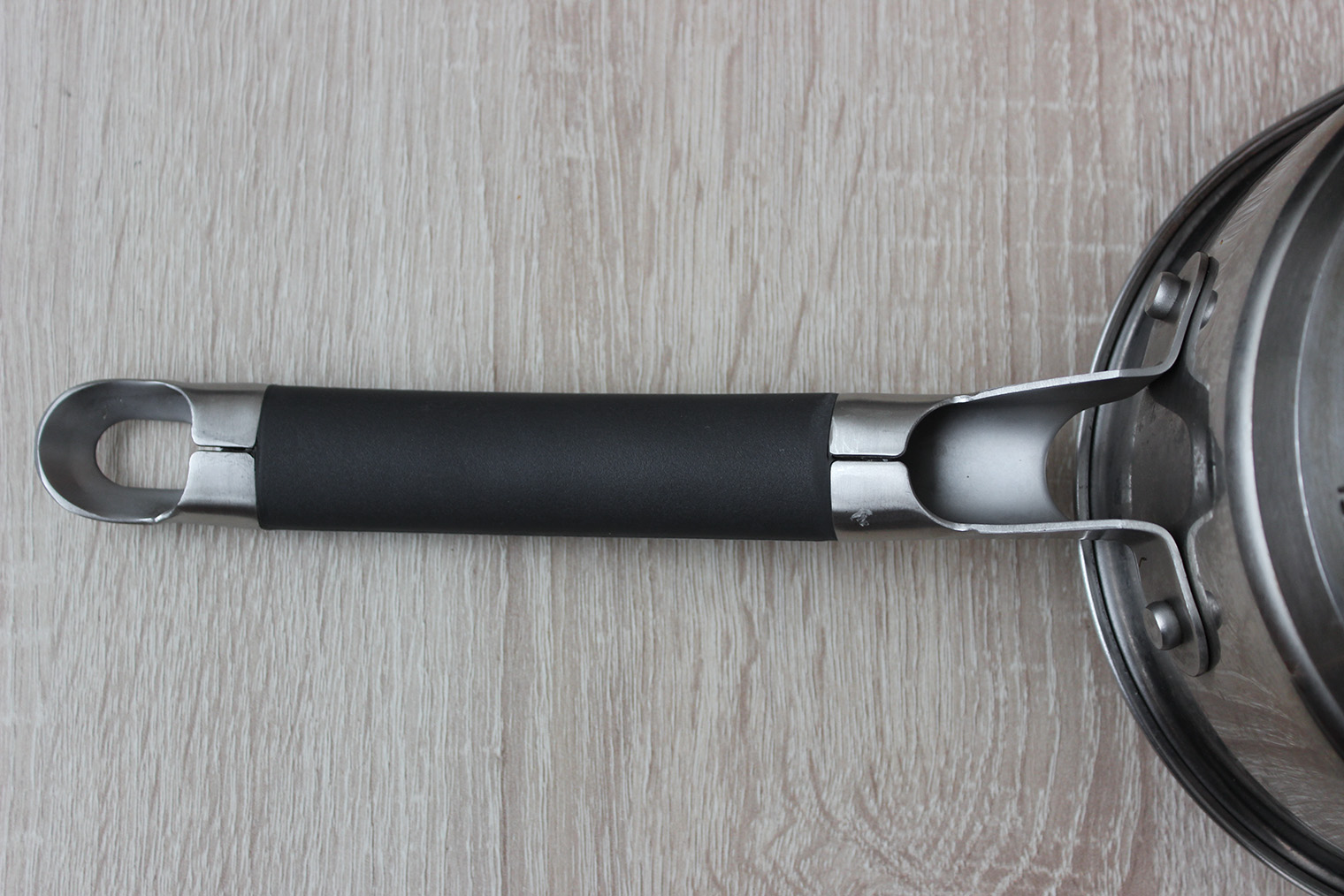 Металлическая ручка сотейника с прорезиненной вставкой. Такую посуду не поставишь в духовку, но об нее и не обожжешься. А еще на конце ручки есть отверстие — за него удобно вешать посуду, чтобы просушить после мытья. Это особенно актуально, когда на кухне мало места. © Галина Назарова