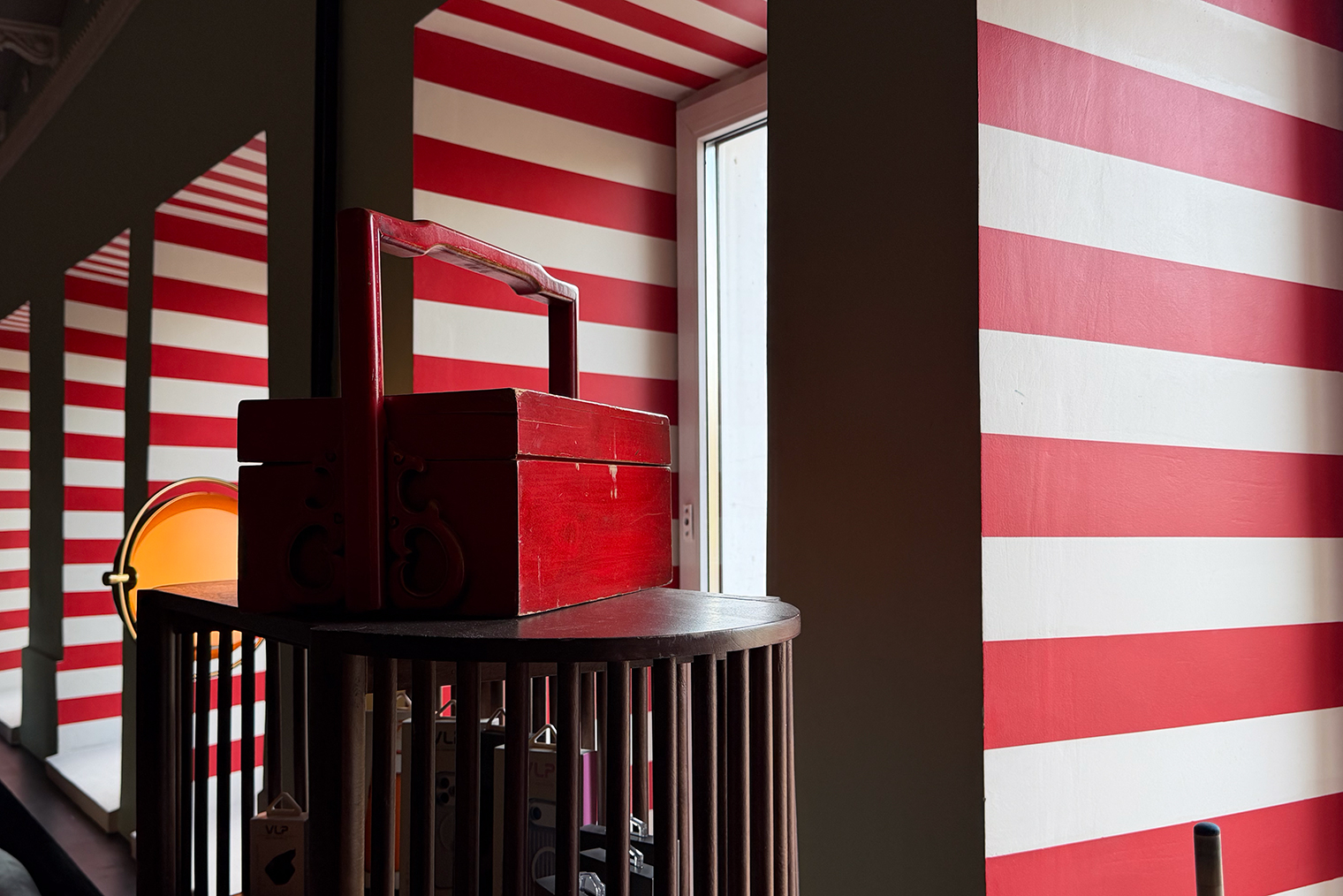 Основная камера iPhone 17 Pro Max отлично справилась со сложной сценой: красные полосы и ящик получились насыщенного оттенка, коробки в тени под полкой и стены сохранили четкость, несмотря на небольшое количество шума