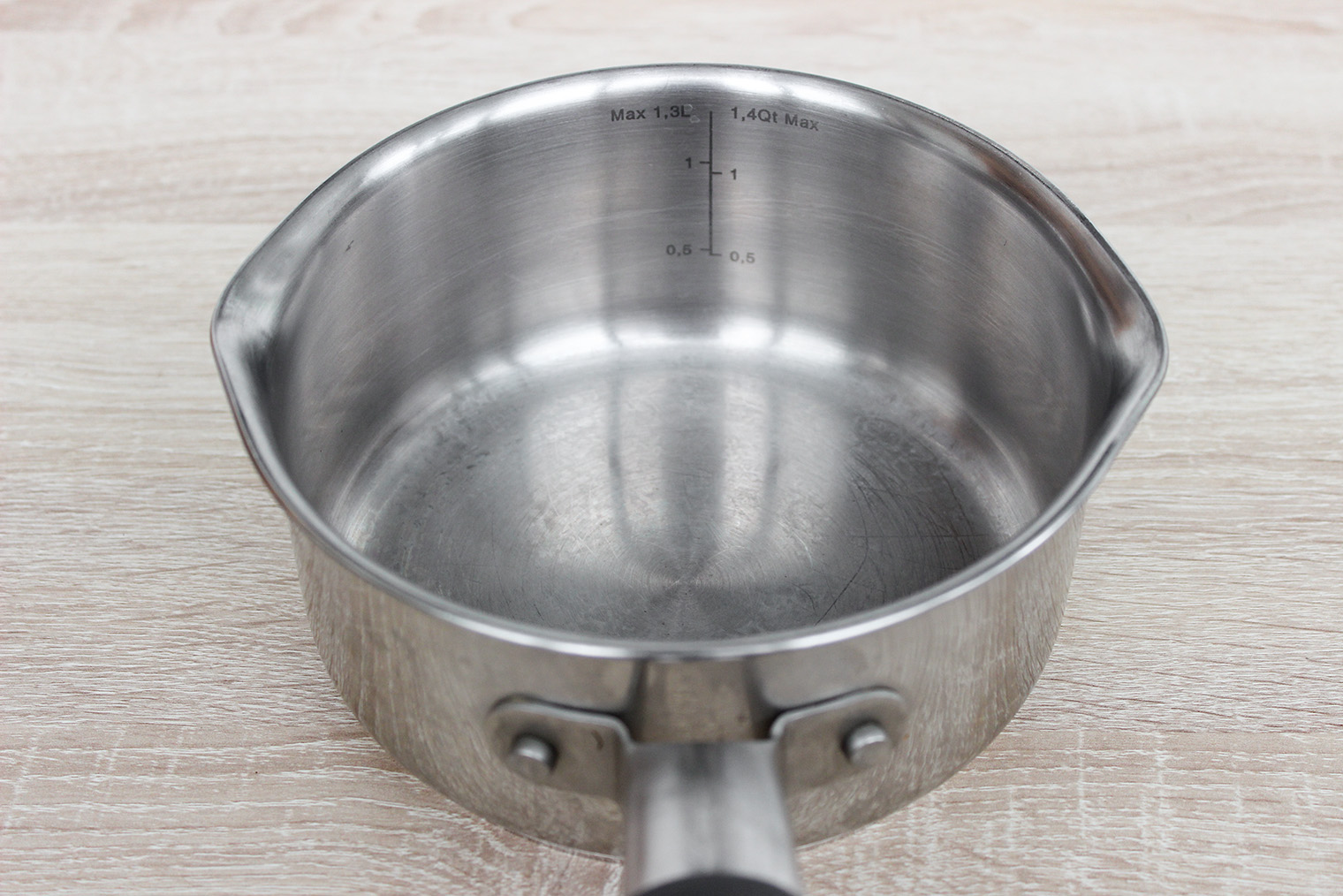 У этого сотейника есть два носика для слива жидких продуктов и метка объема: в посуду можно поместить до 1,3 л жидкости. Если переборщить, все потечет из носиков. Сотейник прослужил полтора года: за это время риски не поблекли. © Галина Назарова