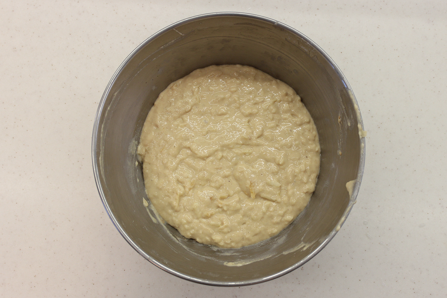 Шаг 2. Муку, ряженку, сахар, яйцо, соль, корицу и разрыхлитель смешайте до однородности венчиком. Добавьте натертое яблоко, еще раз хорошо перемешайте