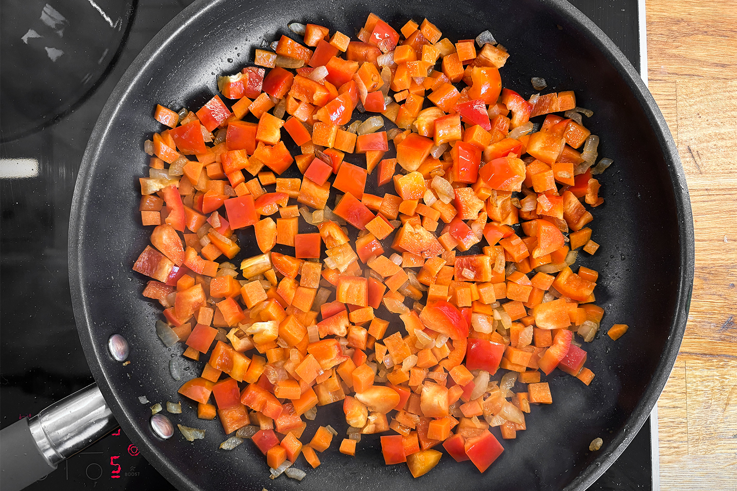 Шаг 2. Начните разогревать сковороду на среднем огне, влейте масло. Лук обжаривайте 2 минуты до золотистости, помешивая. Морковь добавьте и готовьте еще 3—5 минут. Затем добавьте сладкий перец и готовьте еще 3 минуты. Все овощи должны быть мягкими