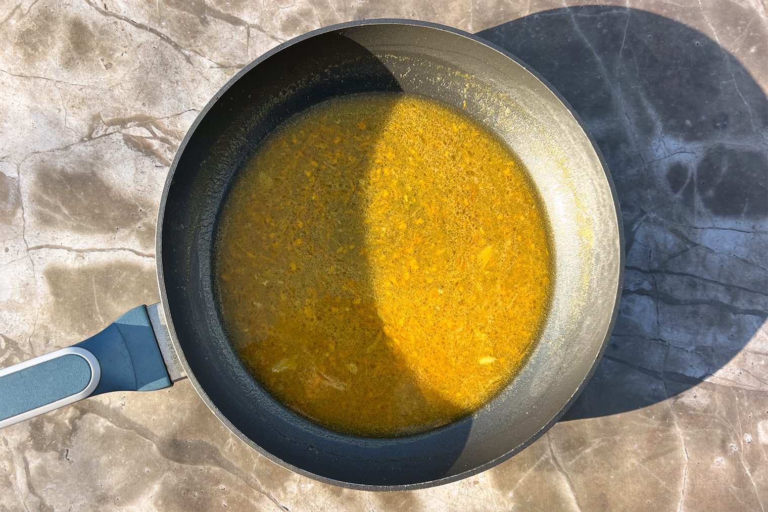 Шаг 2. Цедру апельсина снимите мелкой теркой, сок выжмите. Добавьте все в сковороду и готовьте на среднем огне 3—4 минуты, до консистенции жидкого сиропа, периодически помешивая. Если не собираетесь поджигать блины перед подачей, добавьте алкоголь в начале этого шага