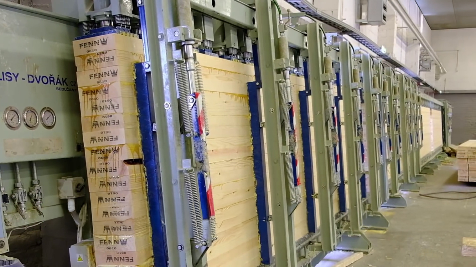 Доски сдавливают друг с другом прессами под большим давлением — за счет этого клей прочно схватывается и получается монолитная конструкция. © Pinska Liimpuit / Youtube