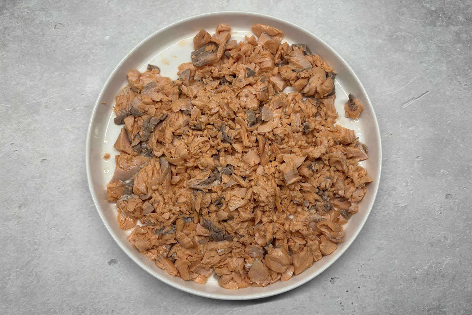 Шаг 2. Рыбу переложите на тарелку и слегка остудите. Руками или вилкой разберите на кусочки, достаньте кости