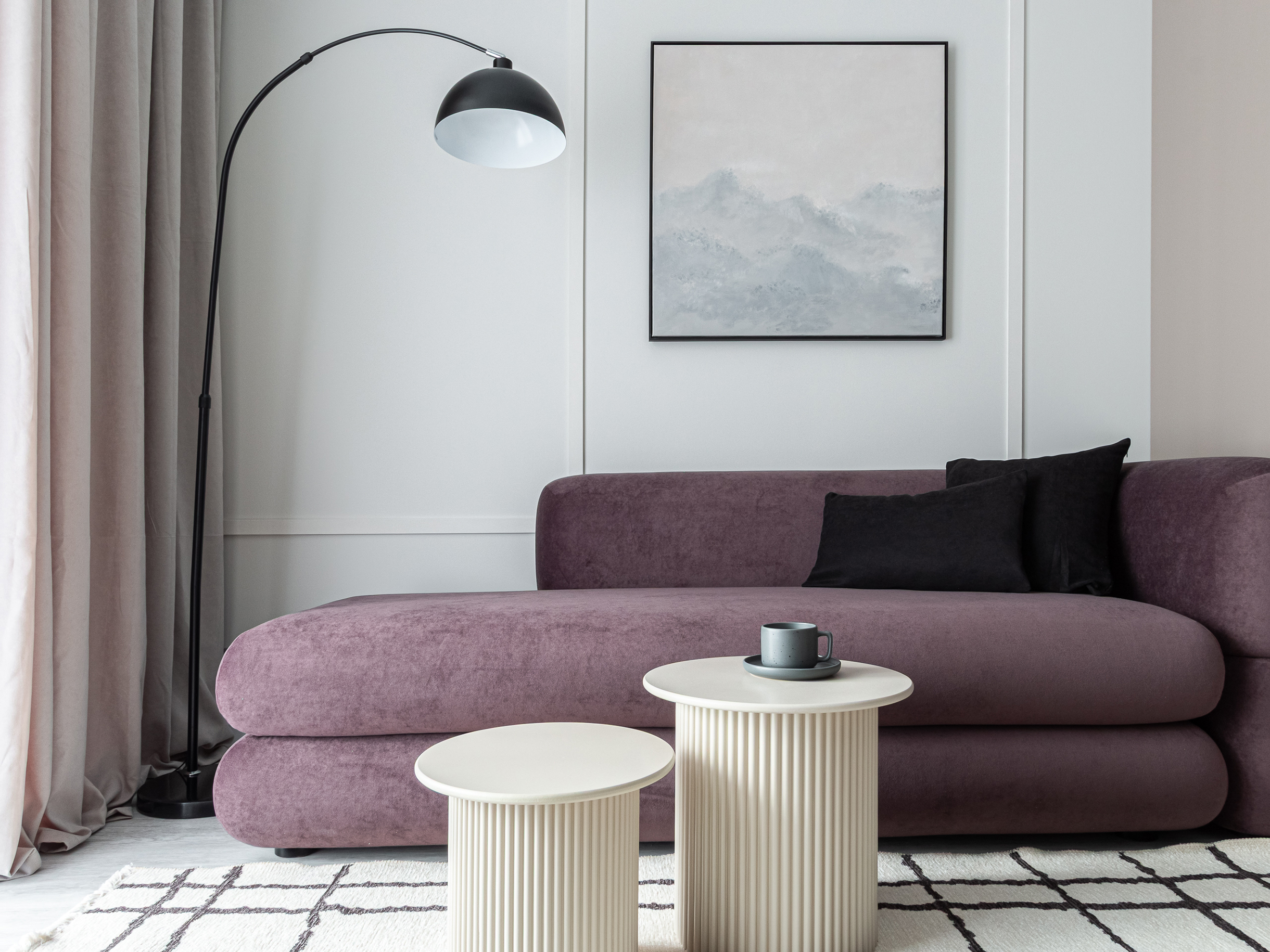 Активно используют и округлые формы: диван, торшер и столики. Это смягчает минимализм. Прямоугольные формы — это фоновые элементы: молдинги, картина и ковер. За счет такого сочетания интерьер не кажется скучным — глаз перемещается с одного предмета на другой, — и мы рассматриваем его с удовольствием