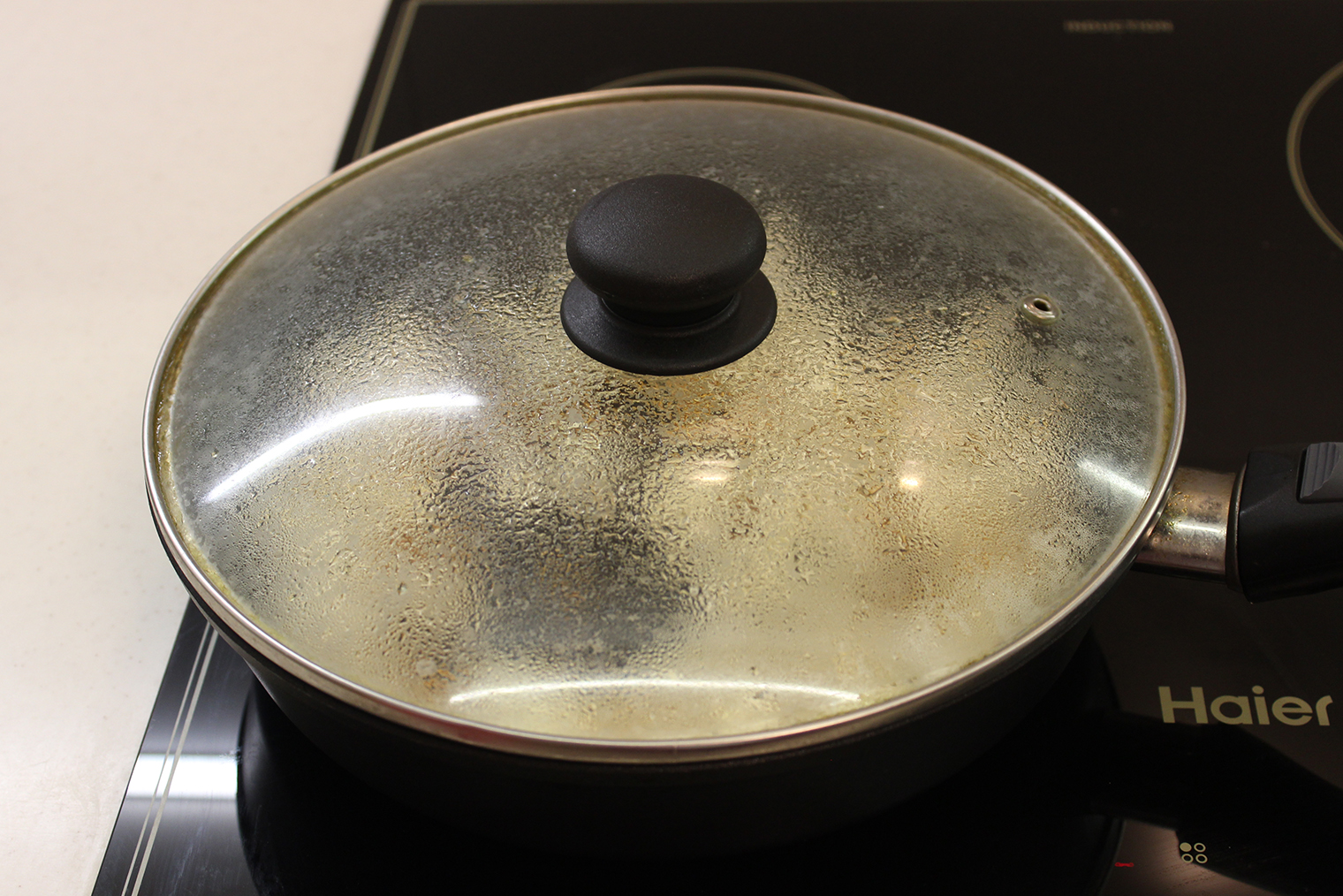 Шаг 2. Примерно через 3 минуты попкорн начнет взрываться, а сахар — превращаться в карамель. В этот момент нужно убавить огонь до среднего. В следующие 2—3 минуты взрывы участятся. Периодически встряхивайте сковороду, чтобы кукуруза не подгорела. Не поднимайте крышку: горячий попкорн может вылететь из сковороды и обжечь