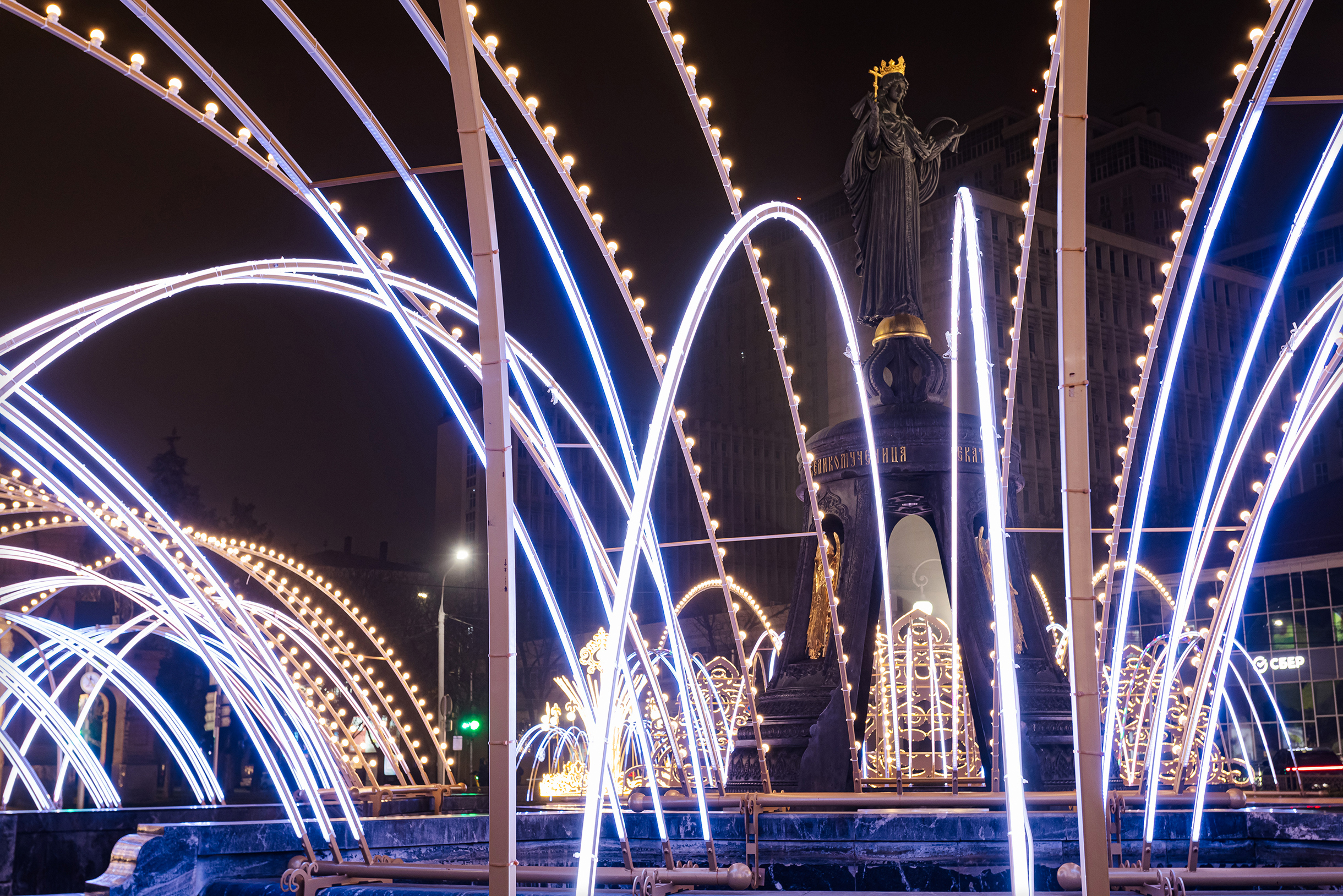 Фонтаны возле памятника святой великомученице Екатерине зимой не работают. Вместо них — световые арки. Дуги похожи на струи воды — кажется, что фонтан работает