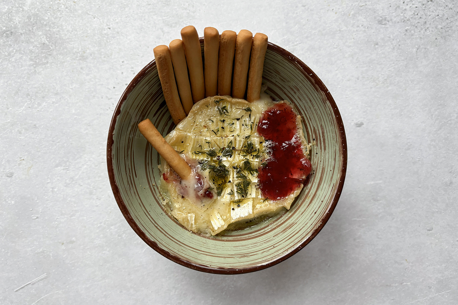 Шаг 3. Готовый бри полейте вареньем. Подавайте сыр горячим с хлебными палочками или кусочками багета. По желанию посыпьте перцем: он добавит закуске пикантности