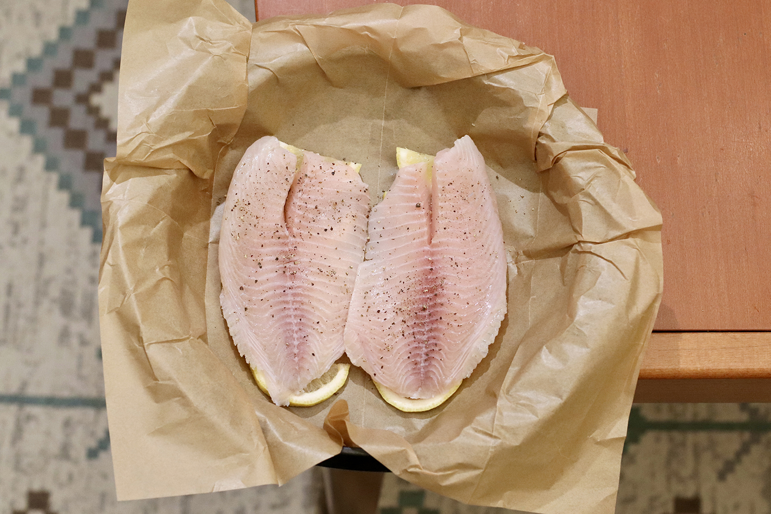 Шаг 3. Филе тилапии положите на лимон. Посолите и поперчите