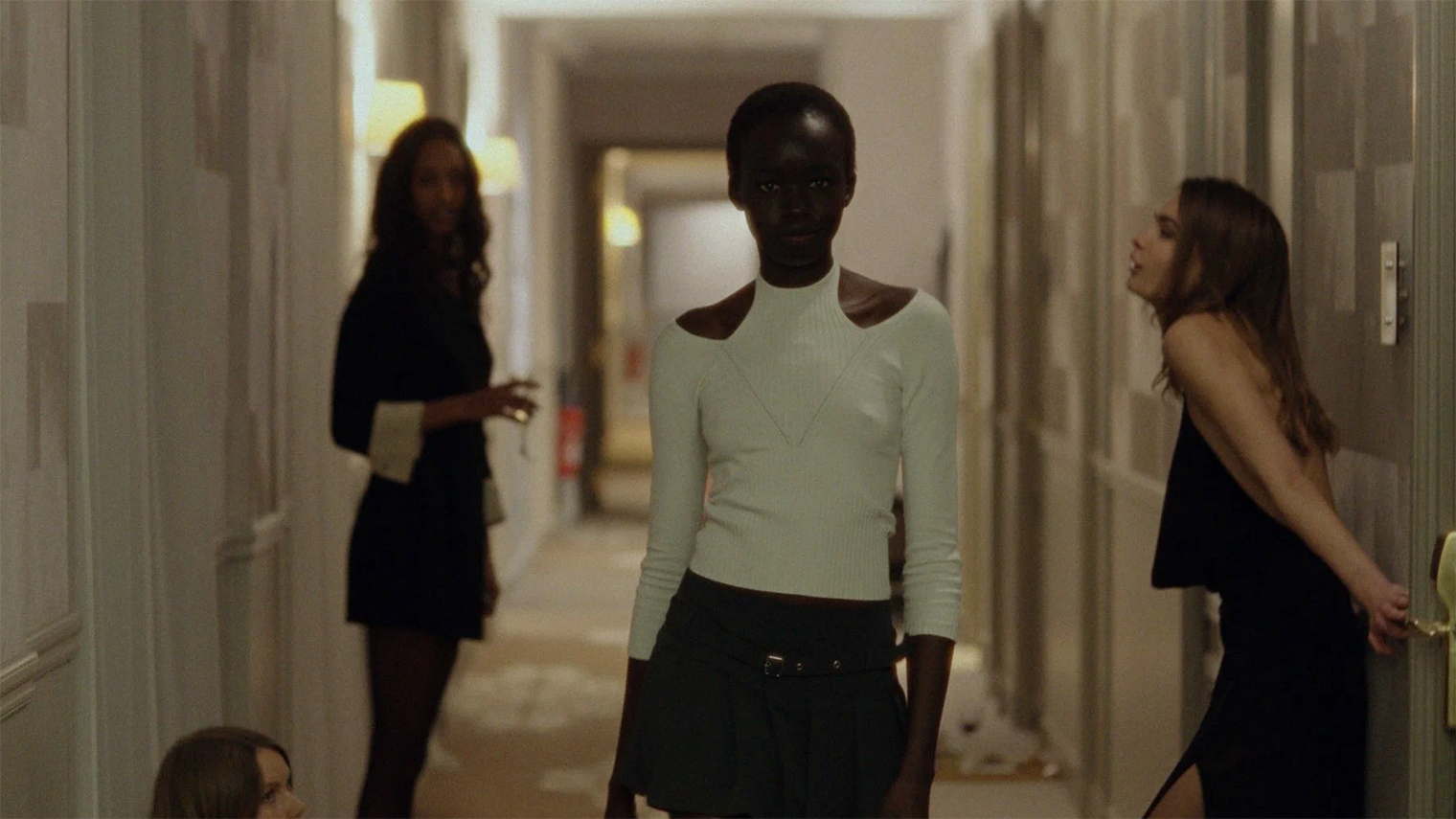 Будучи уже отобранной на свой первый показ, Ада только учится модельной походке. Другие девушки, вопреки стереотипам, подбадривают ее