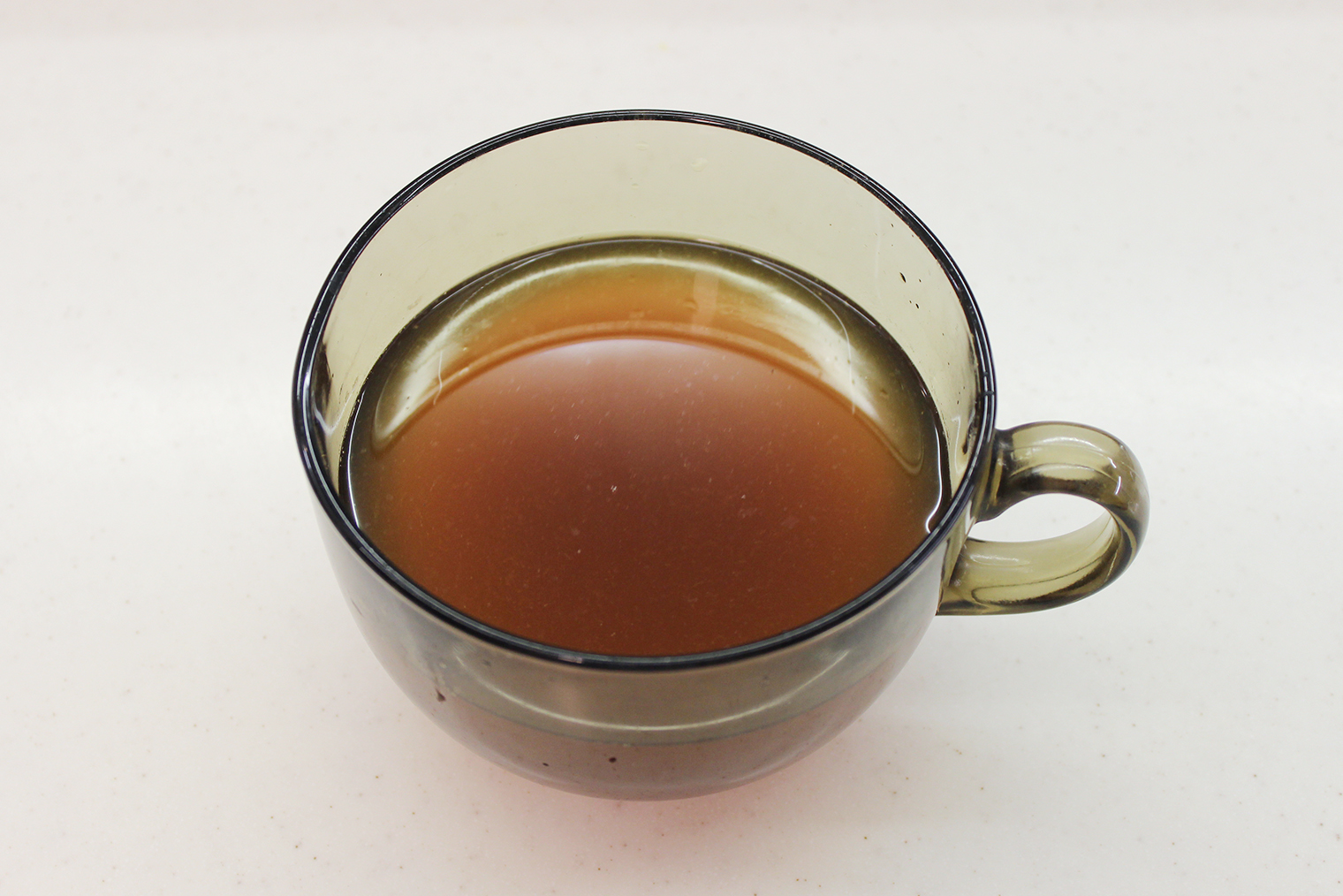 Шаг 3. Чай процедите через сито, добавьте ром, перемешайте. Если напиток остыл, подогрейте на плите или в микроволновке