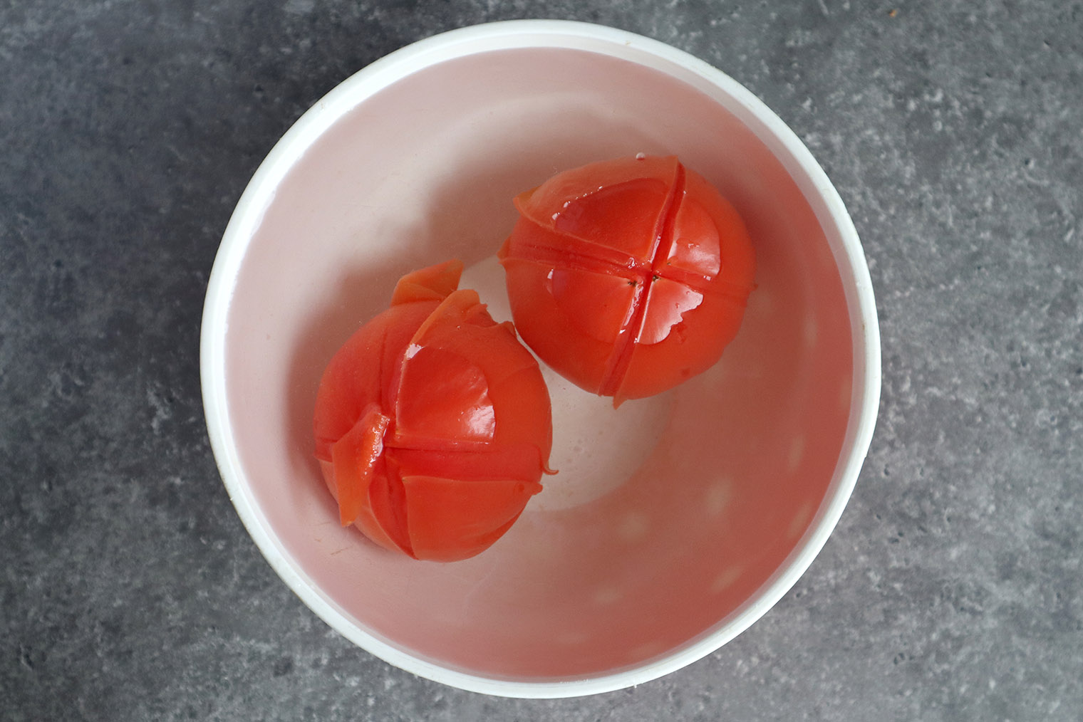 Шаг 3. Помидоры погрузите в ледяную воду на 10 секунд — дополнительно можно положить 3—5 кубиков льда. Благодаря разнице температур помидоры останутся сырыми. Но, если их не охладить, овощи сварятся и превратятся в кашу