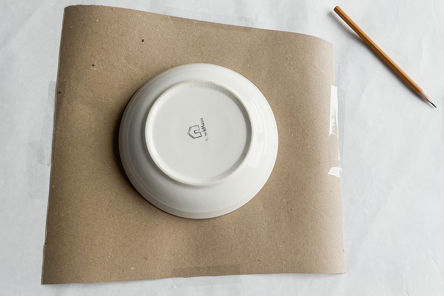 Крепим картон на скотч и обводим тарелку