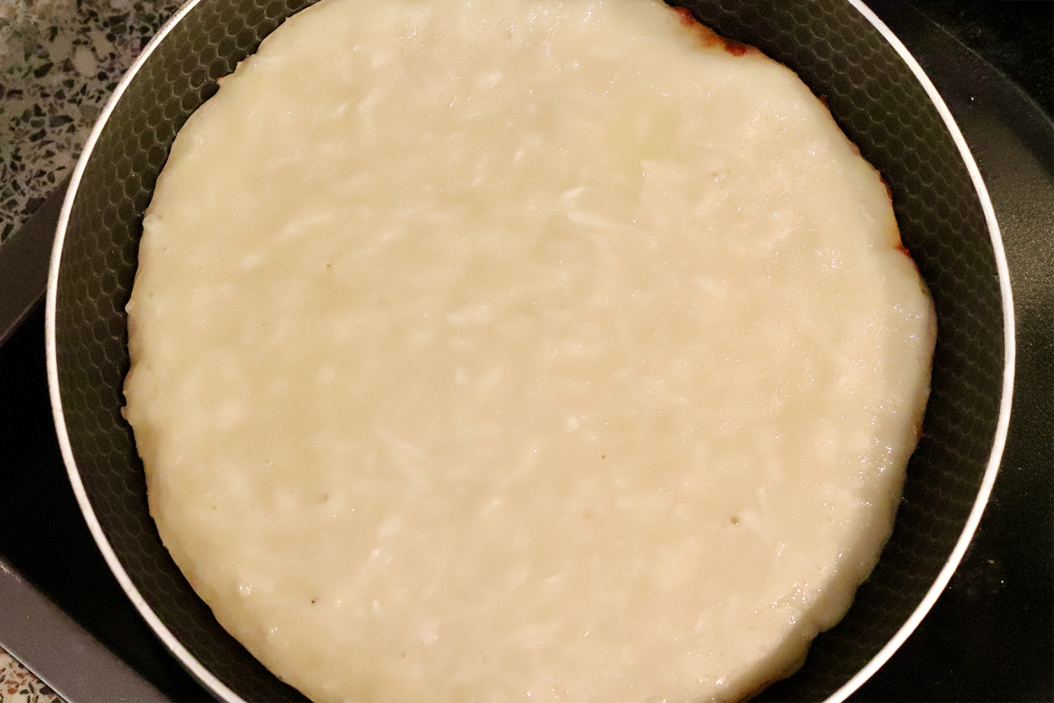 Шаг 3. Сковороду с подсолнечным маслом разогрейте на огне чуть ниже среднего. Выложите в нее тесто и убавьте огонь до слабого