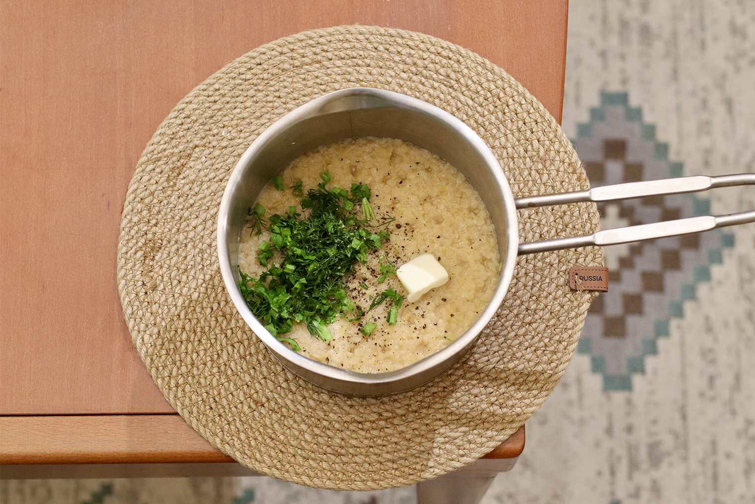 Шаг 3. Кашу снимите с огня, накройте крышкой и оставьте настояться 5—10 минут. Добавьте масло, соль, перец и рубленую зелень, перемешайте и подавайте