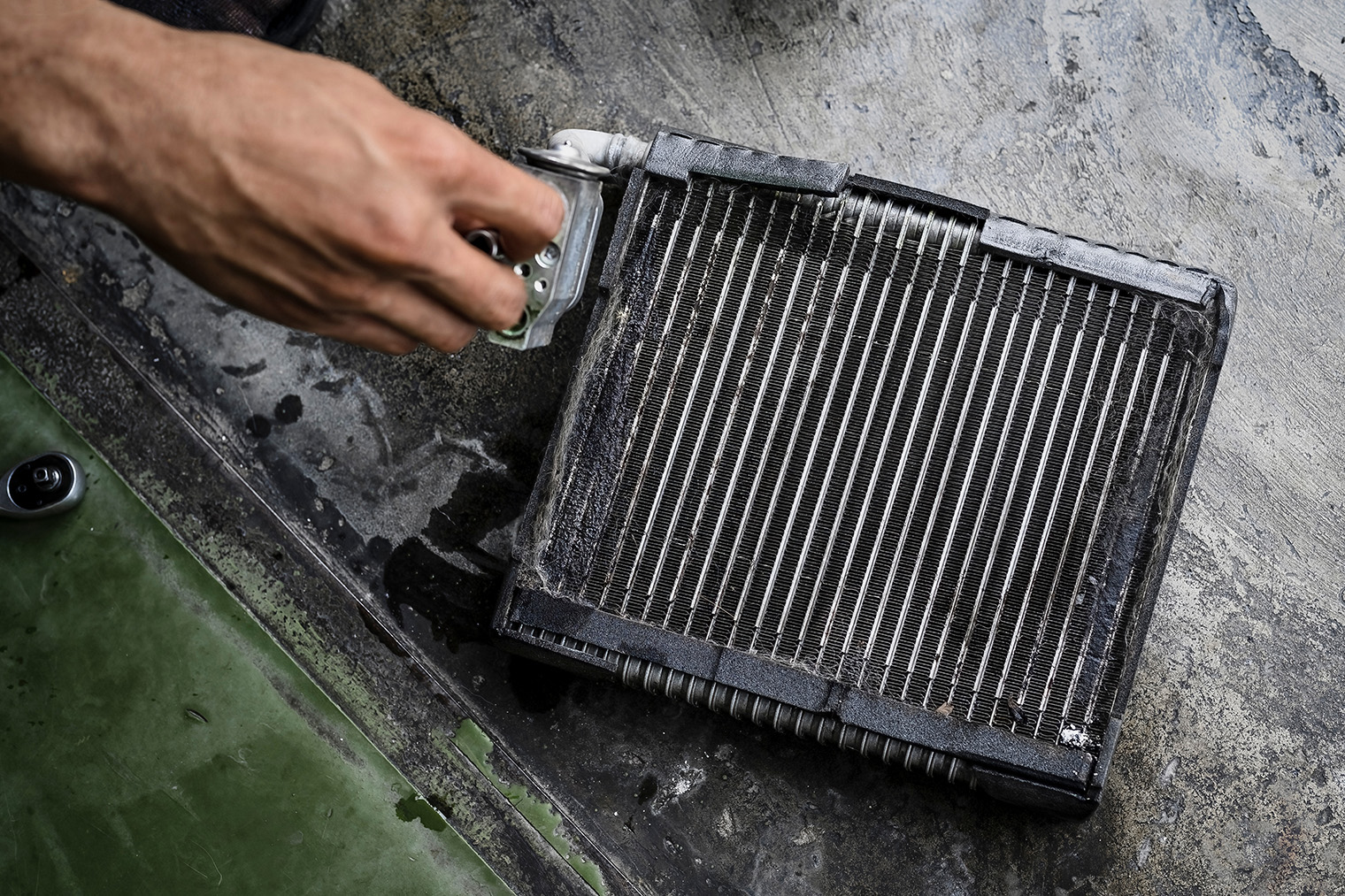 Испаритель кондиционера легко перепутать с радиатором печки, они выглядят одинаково. Но испаритель обычно более грязный: там регулярно скапливается конденсат, а на нем лучше задерживается пыль. Фото: Setta Sornnoi / Shutterstock