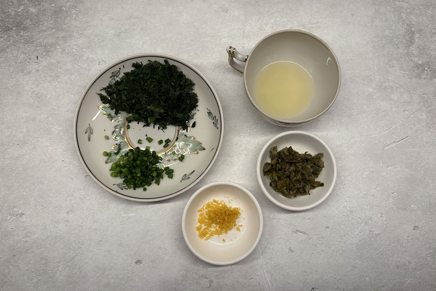 Шаг 3. Зелень, зеленый лук и каперсы мелко порубите. С половины лимона мелкой теркой снимите цедру, выдавите сок