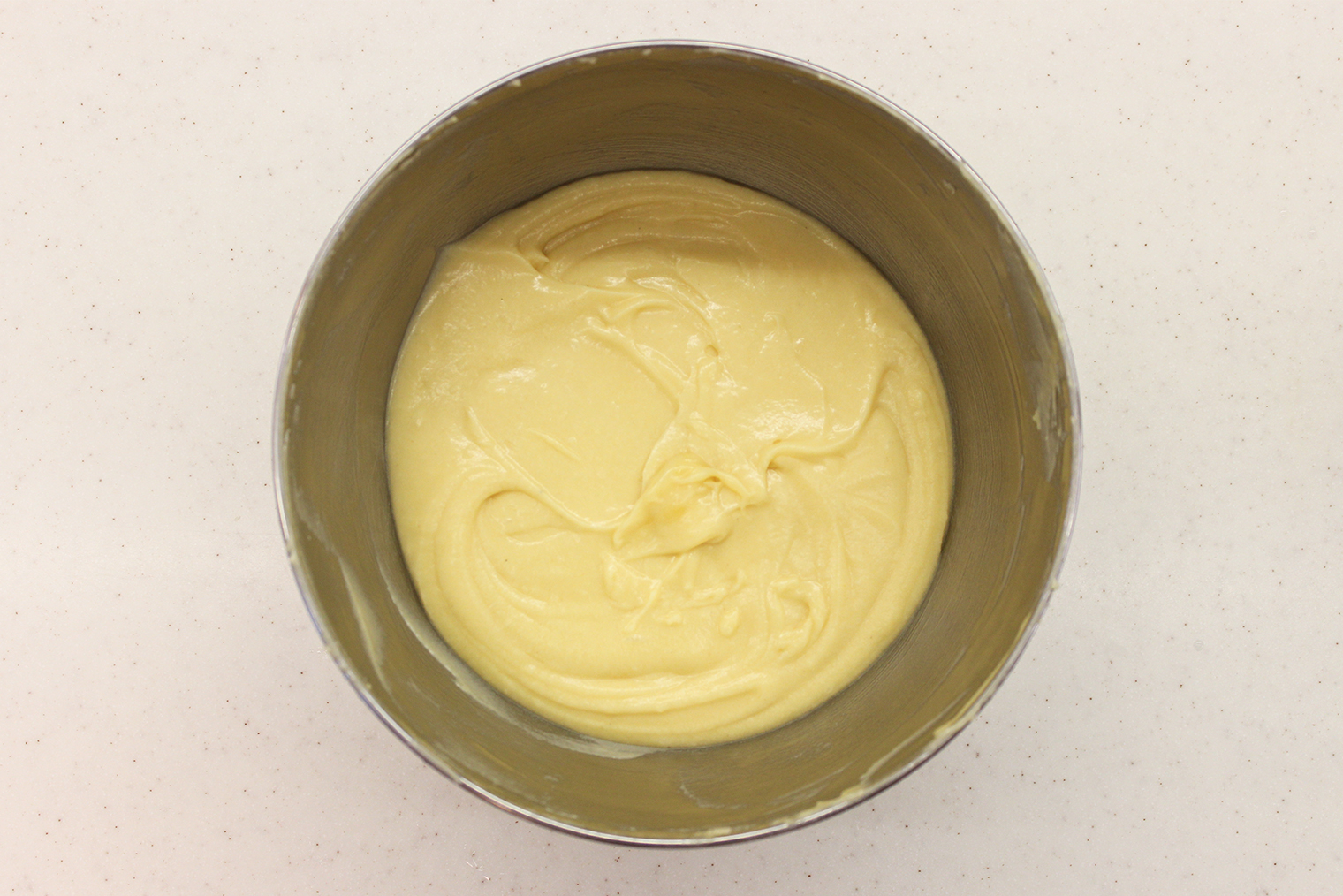 Шаг 3. Муку с кардамоном просейте в массу. Это не обязательно, но так легче замесить равномерное тесто. Добавьте соль, перемешайте все до консистенции густой сметаны. Оставьте смесь на столе на 20 минут, ничем не накрывая. За это время мука впитает влагу и тесто станет нежнее