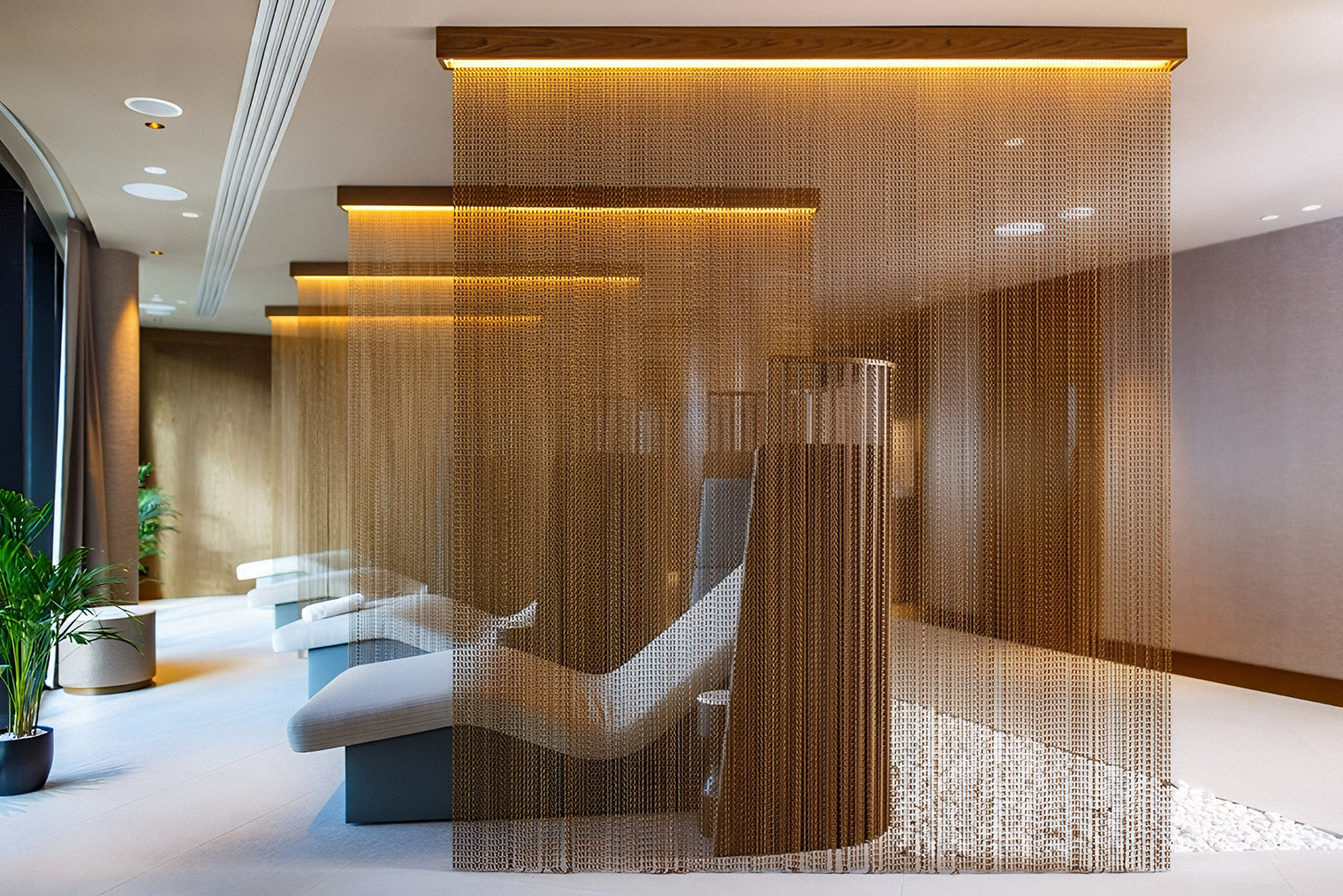 Декоративные перегородки из цепочек, свисающих с потолка с подсветкой в зоне спа отеля «Хилтон». Такой прием позволяет создать приватные массажные зоны, сохранив объем пространства. Конструкции здесь — яркий акцент и узнаваемый декоративный элемент дизайна помещения. Источник: hilton.com