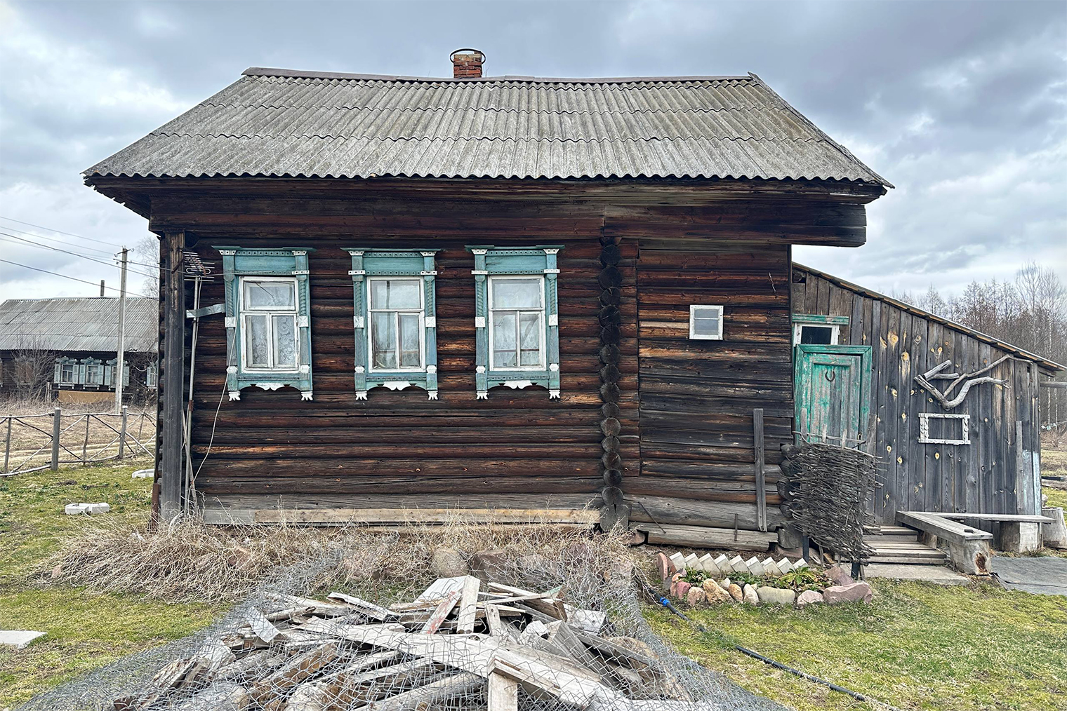Дом был построен из сруба, справа — та самая пристройка. Крыша выглядела невзрачно, зато не протекала