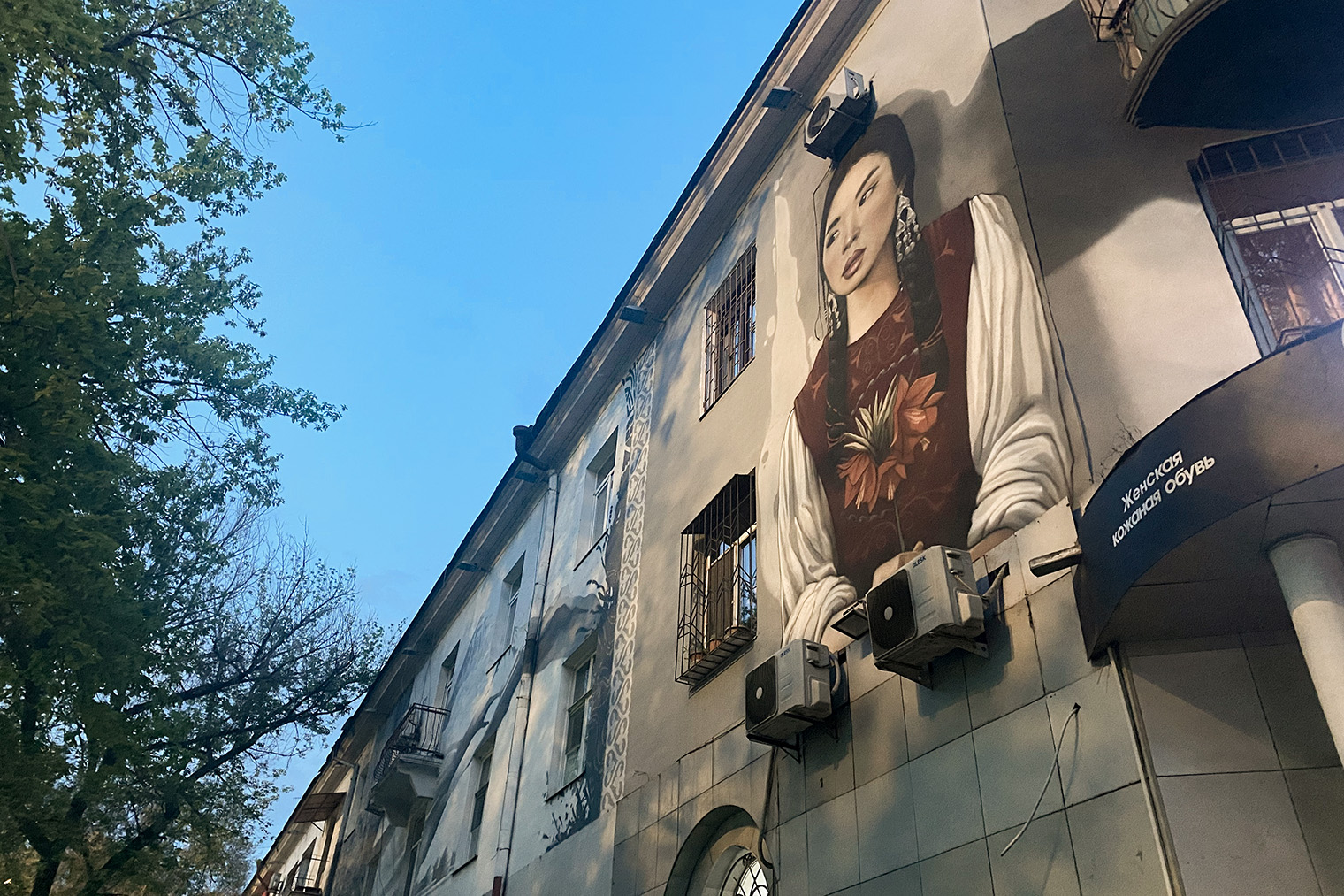 Некоторые дома в центре города украшают муралы с изображением людей в национальных нарядах