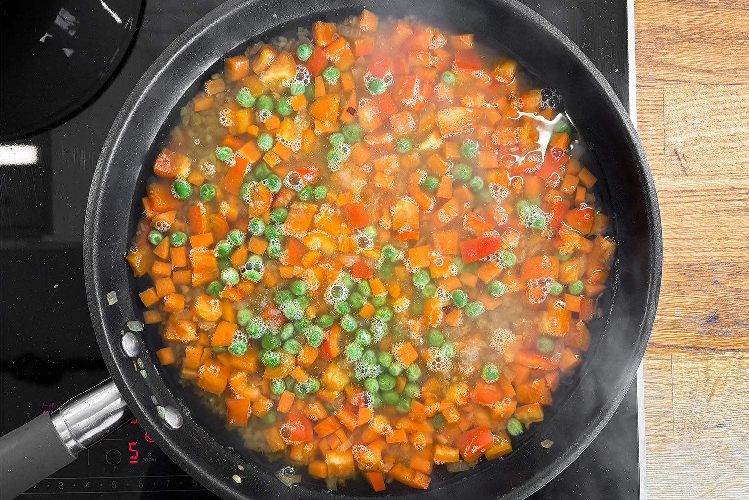 Шаг 4. Воду вскипятите и влейте в сковороду, добавьте сушеный чеснок, соль и перец. Доведите жидкость до кипения и накройте крышкой. Убавьте огонь до слабого и готовьте 20—25 минут, пока крупа полностью не впитает жидкость