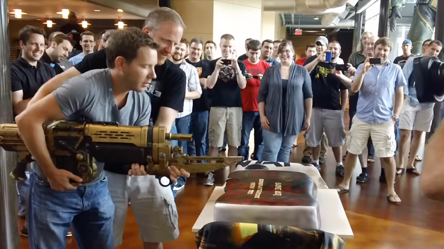 Разработчики Клифф Блежински и Род Фергюссон воспользовались репликой Ретро Лансера, чтобы разрезать торт в честь празднования скорого релиза Gears of War 3. Кадр: Epic Games