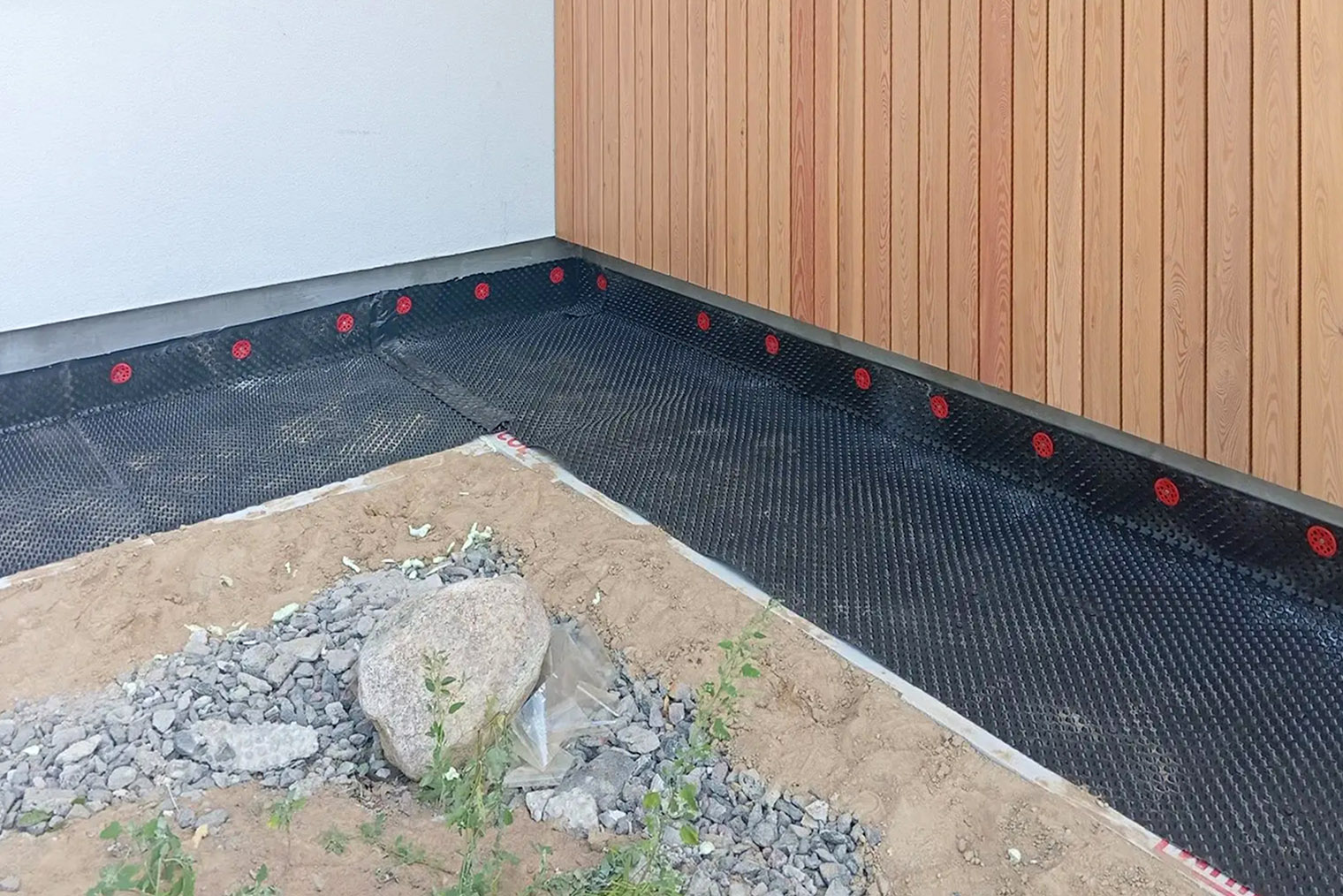 Гидроизоляция защищает отмостку от проникновения влаги и дальнейшего растрескивания бетона. Здесь использовали гидроизоляционную мембрану Planter. © Дмитрий Безделов