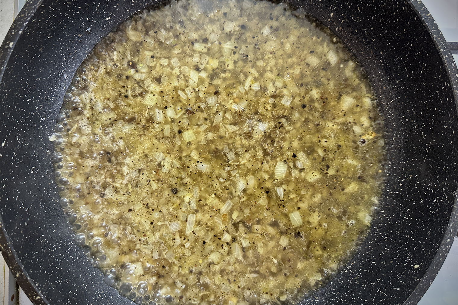 Шаг 4. В сковороду влейте бульон. Доведите до кипения, убавьте огонь до среднего и уваривайте соус 5—7 минут без крышки, пока он не уменьшится в объеме вдвое