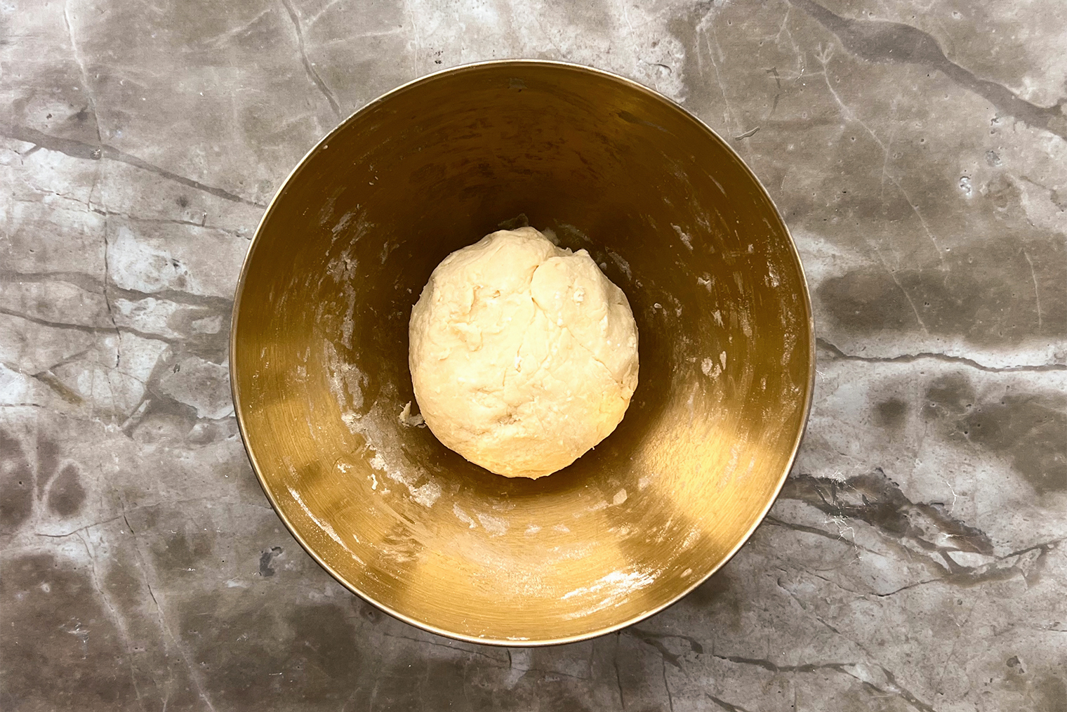 Если вы добавили не всю муку, а тесто уже собралось в ком, больше добавлять ее не нужно