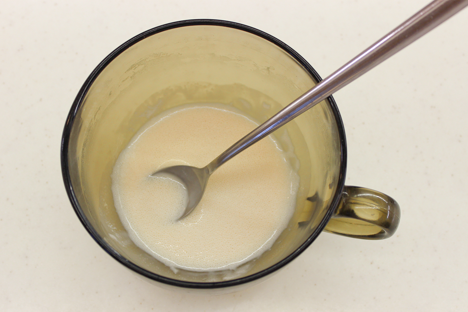 На поверхности смеси должны появиться маленькие пузырьки — это значит, дрожжи заработали. Точное время зависит от свежести дрожжей, температуры молока и воздуха в помещении