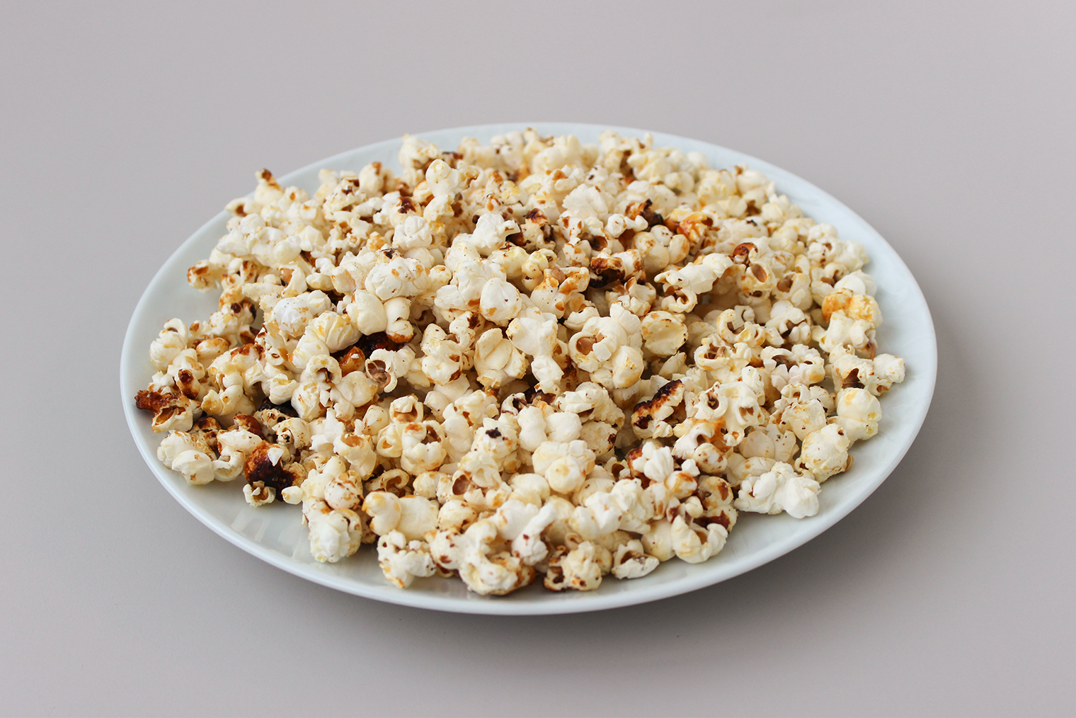 Шаг 4. Готовый попкорн переложите в глубокую миску или широкую тарелку и подавайте