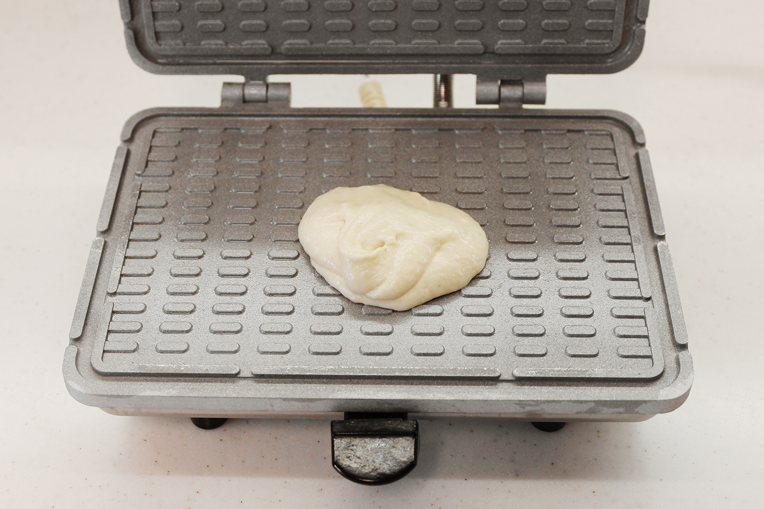 Шаг 4. Начните разогревать вафельницу. Время нагрева зависит от устройства: моей нужно 15—20 минут. Если на вашей модели есть индикатор, ориентируйтесь на него. Разогретую панель смажьте тонким слоем растительного масла, выложите 1 ст. л. теста. Прижмите крышкой и выпекайте 1 минуту. Возможно, вашей вафельнице понадобится чуть больше или чуть меньше времени