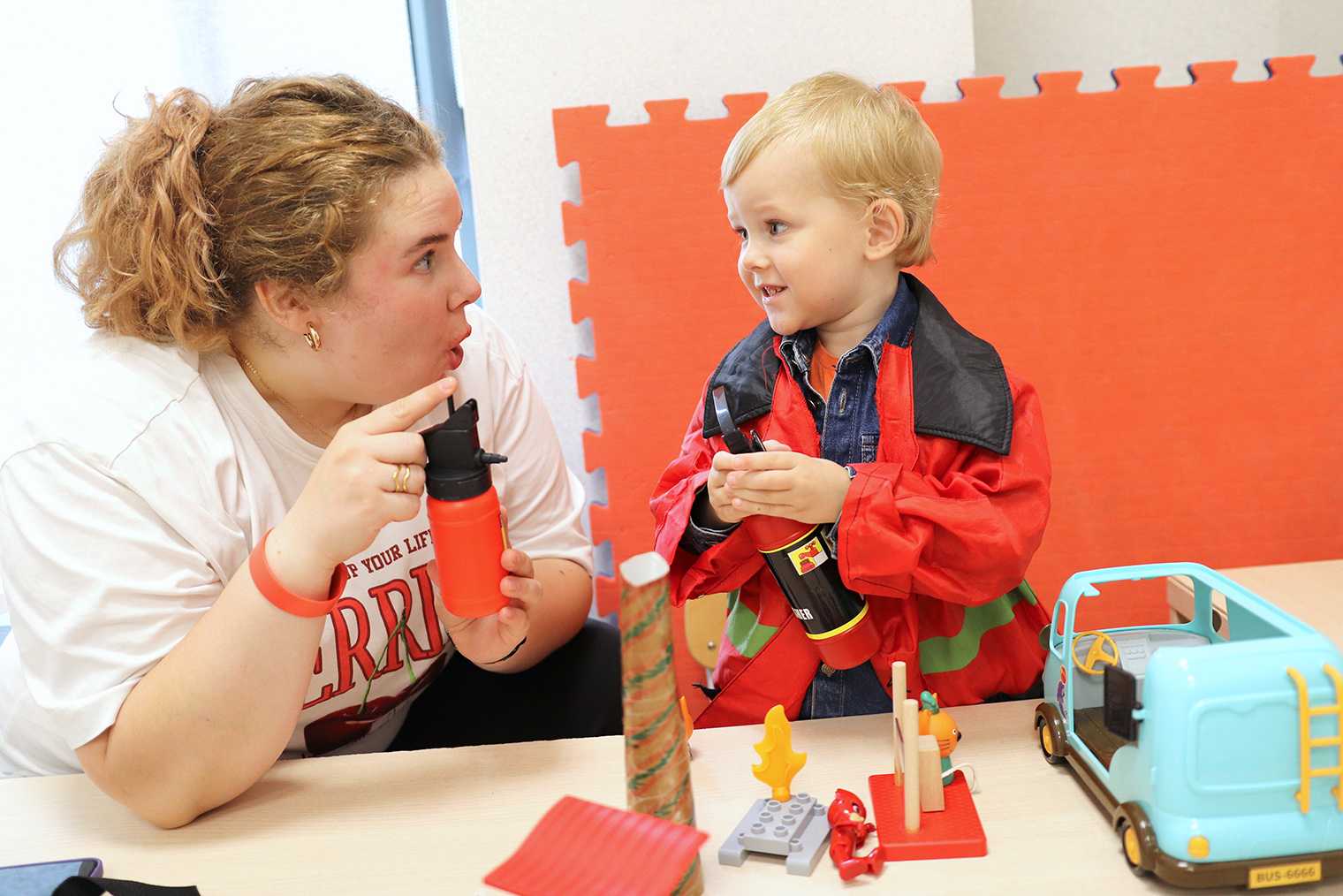 Занятие по программе «Джаспер». Специалист отрабатывает с Марком навык совместного внимания: «показать, чтобы поделиться». В будущем, используя этот жест, ребенок сможет делиться впечатлениями от увиденного. Специалист обучает через игру — мальчику нравится проигрывать сюжет с пожарными